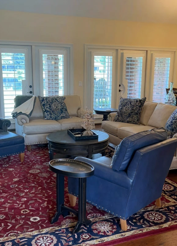 Living room with a leather sofa and blue leather chair on a red patterned rug